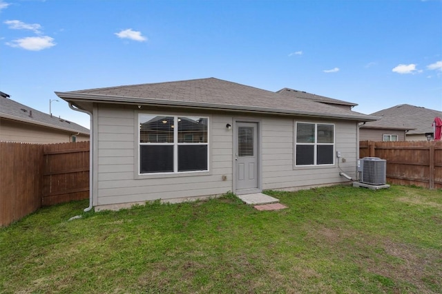 back of house featuring a yard and central AC