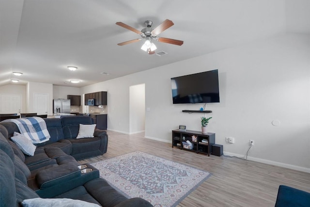 living room featuring ceiling fan and light hardwood / wood-style flooring