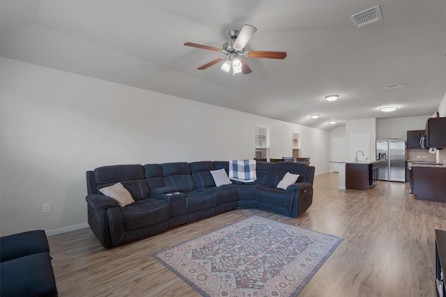 living room with ceiling fan, sink, and light hardwood / wood-style floors