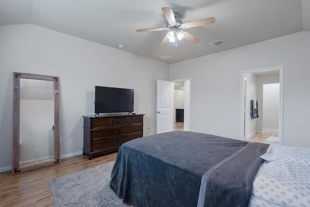 bedroom with light hardwood / wood-style flooring, vaulted ceiling, and ceiling fan