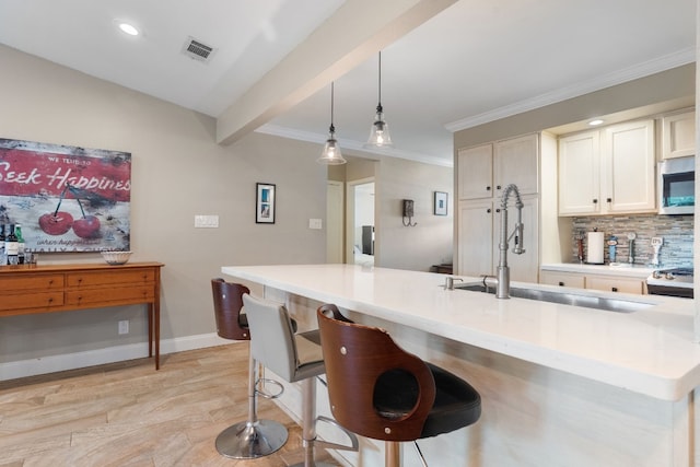 8406 Seminary Ridge Dr, Austin, TX 78745 - kitchen with stainless steel microwave, light wood-style floors, backsplash, light countertops, and decorative light fixtures