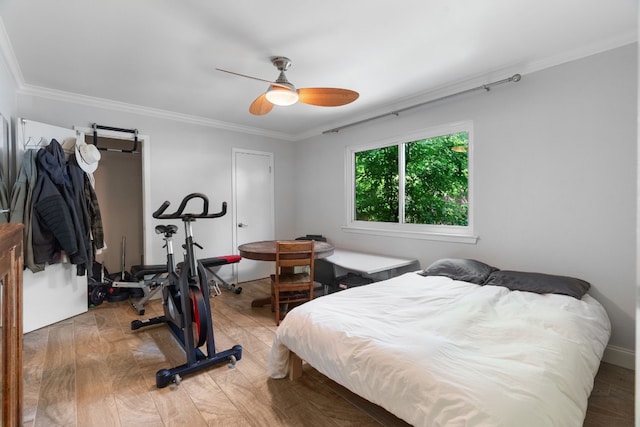 bedroom with hardwood / wood-style floors, crown molding, and ceiling fan