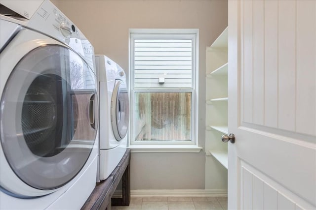 washroom featuring separate washer and dryer and light tile patterned floors