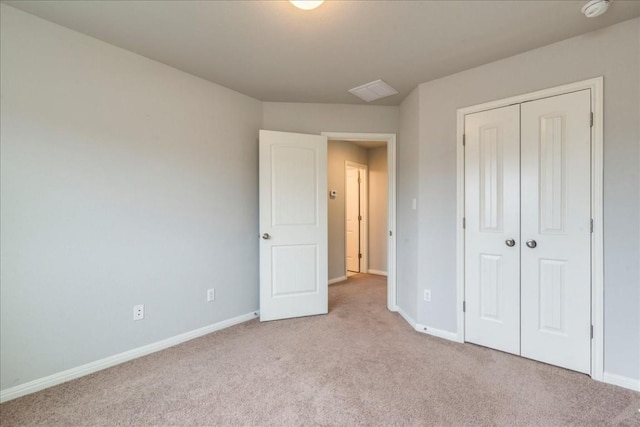 unfurnished bedroom featuring light colored carpet and a closet