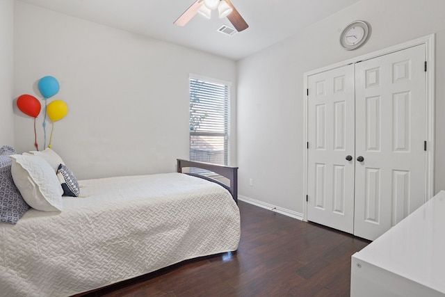 bedroom with dark wood-type flooring, ceiling fan, and a closet