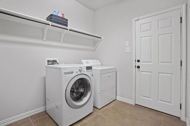 laundry room featuring light tile patterned floors and washer and clothes dryer