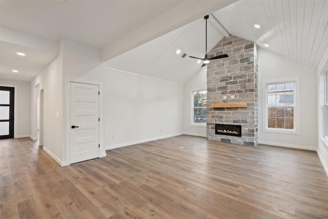 unfurnished living room featuring a fireplace, lofted ceiling with beams, wood finished floors, and baseboards