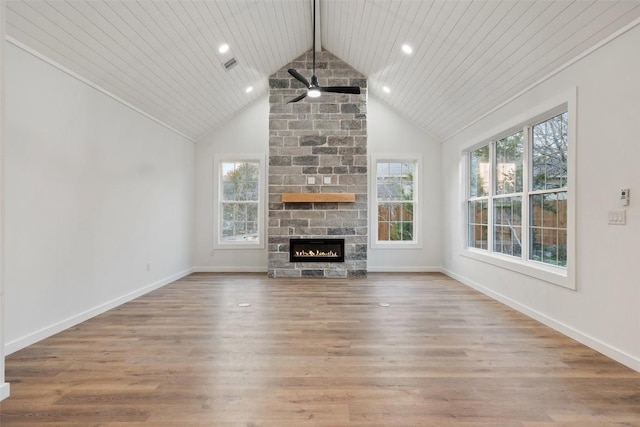 unfurnished living room featuring baseboards, a stone fireplace, and wood finished floors