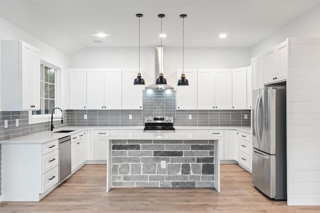 kitchen with stainless steel appliances, light wood-type flooring, wall chimney range hood, and a sink