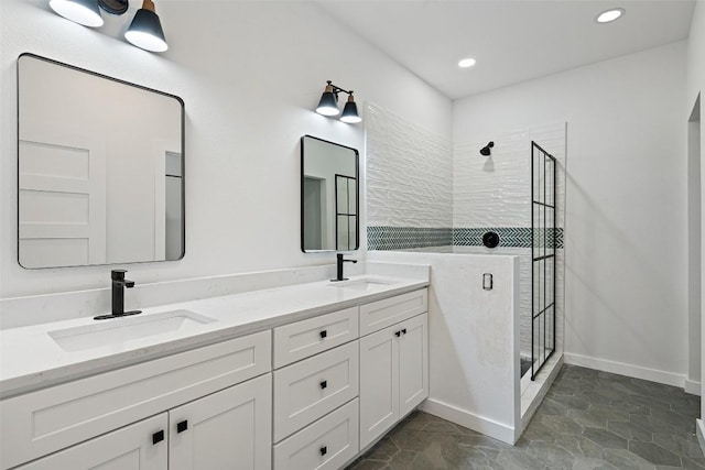 full bath with a sink, double vanity, and a walk in shower