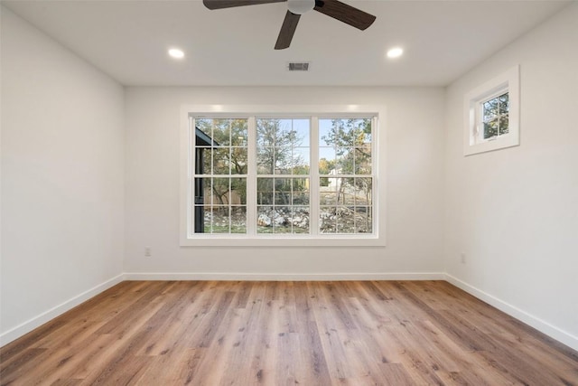 unfurnished room featuring visible vents, plenty of natural light, and baseboards