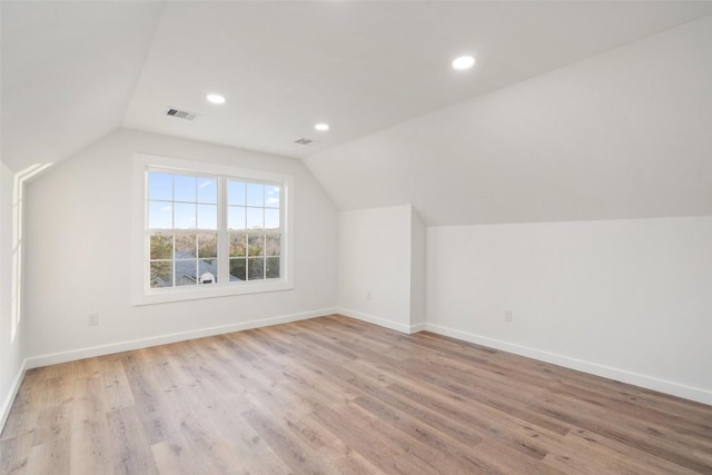 bonus room with lofted ceiling, wood finished floors, visible vents, and baseboards