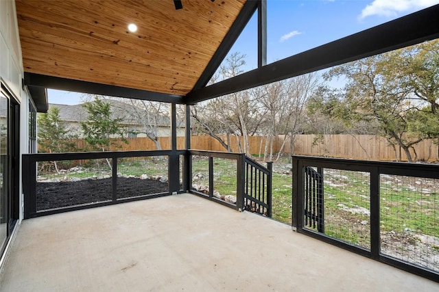 unfurnished sunroom featuring wooden ceiling, plenty of natural light, and lofted ceiling