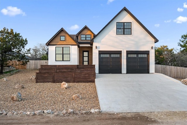 modern farmhouse style home with fence, a garage, and driveway