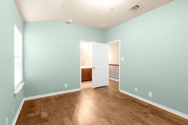 unfurnished bedroom featuring hardwood / wood-style flooring and multiple windows