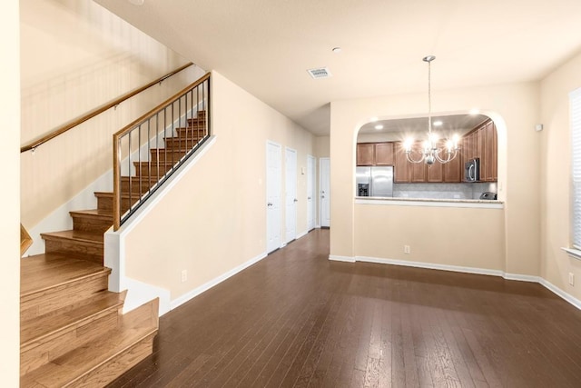 interior space with dark wood-type flooring and an inviting chandelier