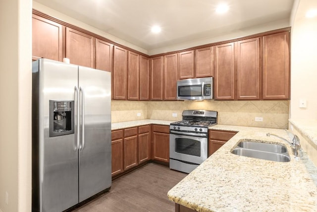 kitchen with sink, light stone counters, tasteful backsplash, dark hardwood / wood-style floors, and stainless steel appliances