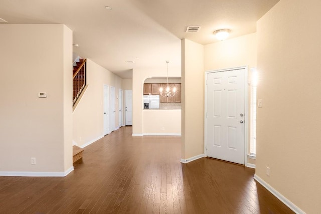 interior space with dark hardwood / wood-style floors and a notable chandelier