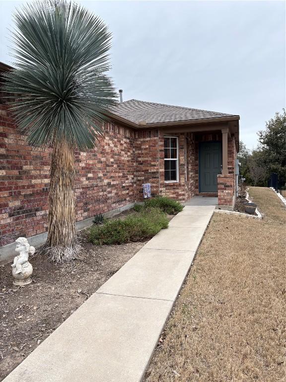 view of exterior entry featuring a yard