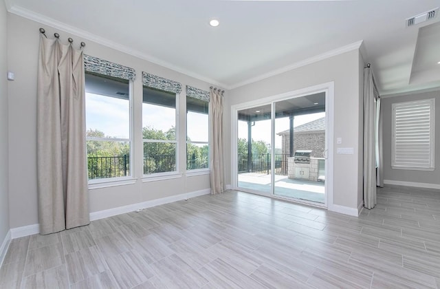 spare room with ornamental molding and light hardwood / wood-style flooring