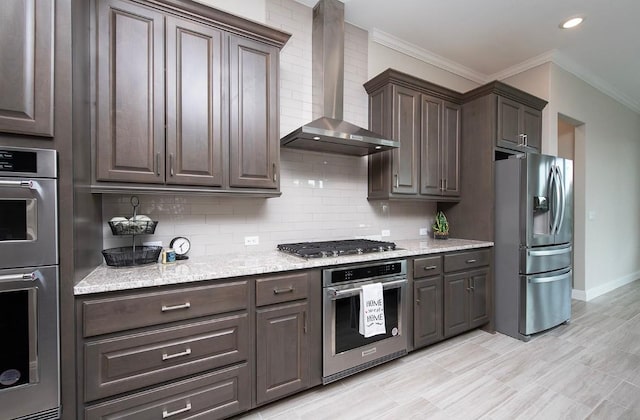 kitchen with crown molding, backsplash, dark brown cabinets, stainless steel appliances, and wall chimney exhaust hood