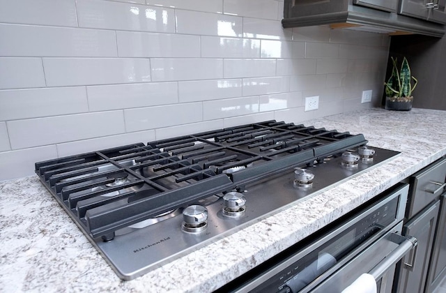 room details featuring tasteful backsplash and stainless steel gas cooktop