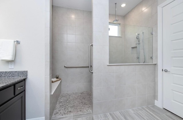 bathroom with vanity and a tile shower