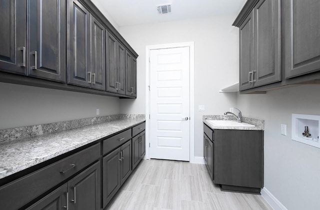 washroom featuring cabinets, sink, and washer hookup