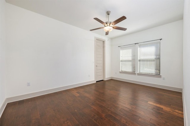 empty room with ceiling fan and dark hardwood / wood-style flooring