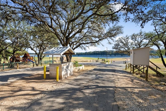 surrounding community with a water view and a playground