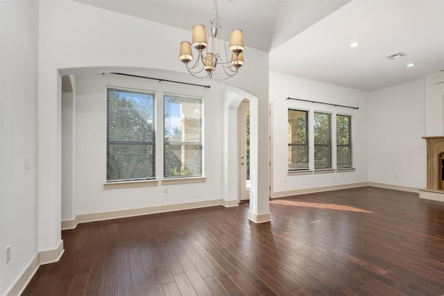 unfurnished dining area featuring an inviting chandelier and dark hardwood / wood-style flooring