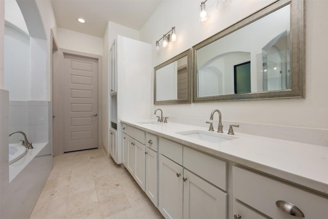 bathroom featuring vanity and tiled tub