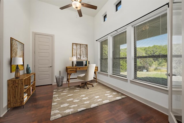 office space with ceiling fan, a towering ceiling, and dark hardwood / wood-style flooring