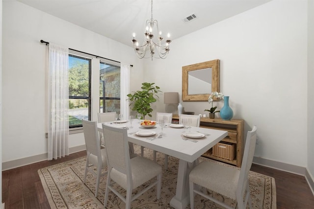 dining room featuring dark wood-type flooring and a chandelier