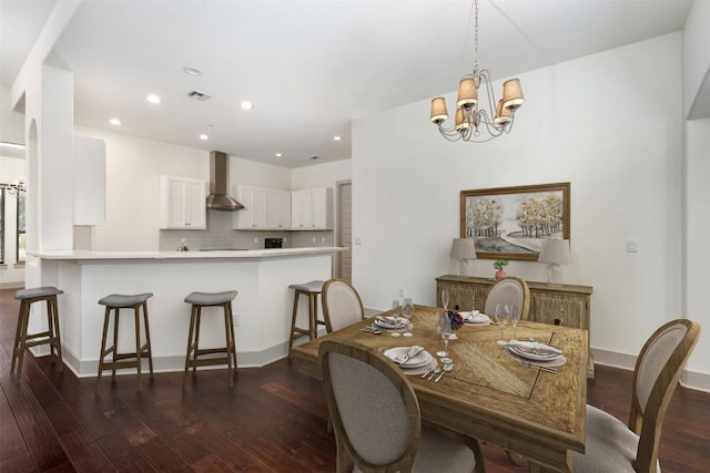 dining room with dark wood-type flooring and an inviting chandelier