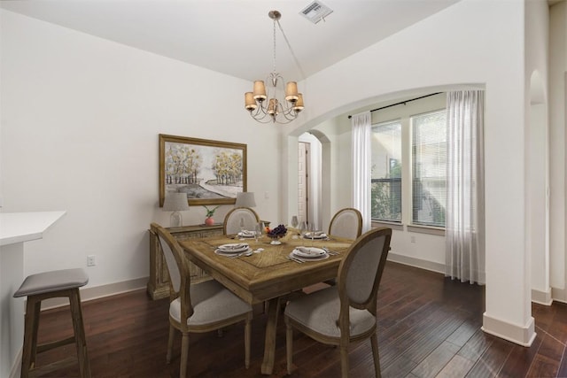 dining room with dark hardwood / wood-style floors and a notable chandelier