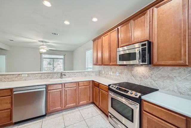 kitchen with sink, ceiling fan, stainless steel appliances, tasteful backsplash, and light tile patterned flooring