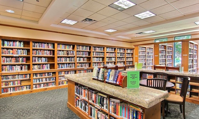 254 Monument Hill Trl, Georgetown, TX 78633 - living area with visible vents, a drop ceiling, carpet flooring, and wall of books