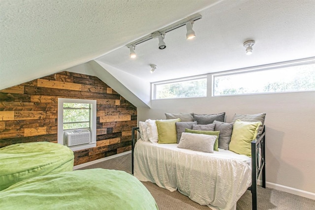 carpeted bedroom featuring lofted ceiling, cooling unit, wooden walls, and a textured ceiling