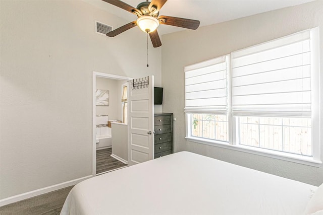 bedroom featuring dark carpet, ceiling fan, and ensuite bathroom