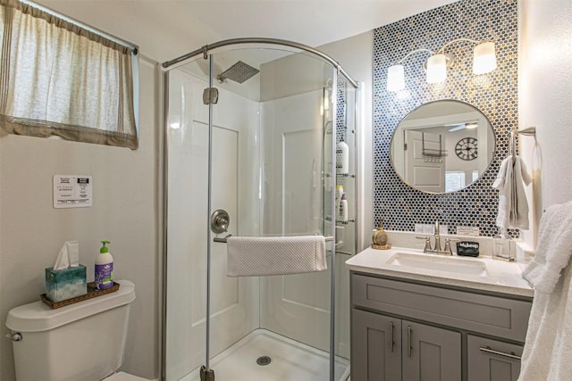 bathroom featuring an enclosed shower, vanity, and toilet