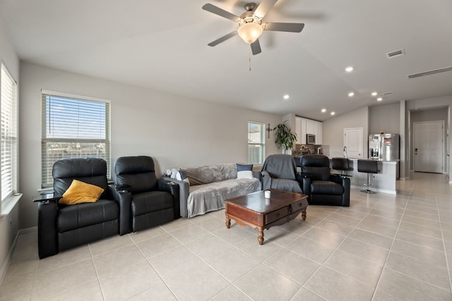 living room featuring vaulted ceiling, light tile patterned floors, and ceiling fan