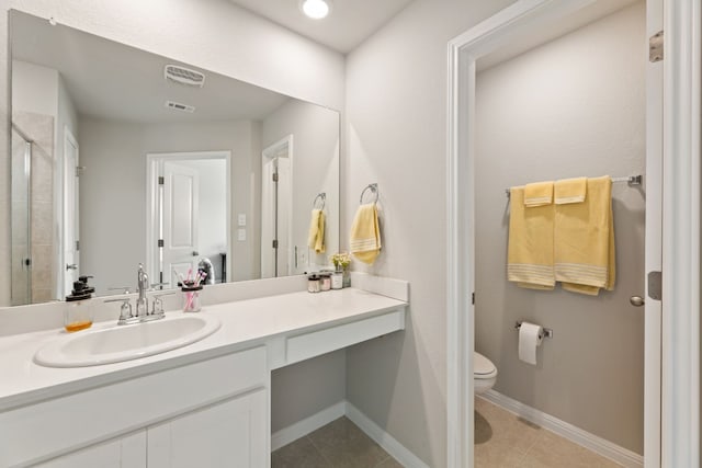 bathroom with tile patterned flooring, vanity, a shower with shower door, and toilet