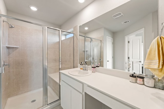 bathroom with vanity and a shower with door