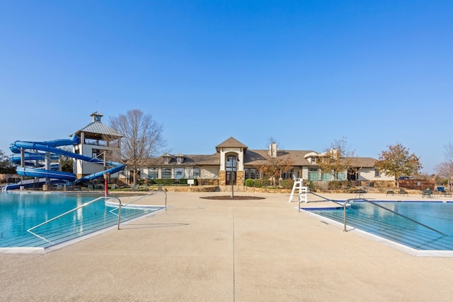 view of swimming pool featuring a gazebo, a water slide, and a patio