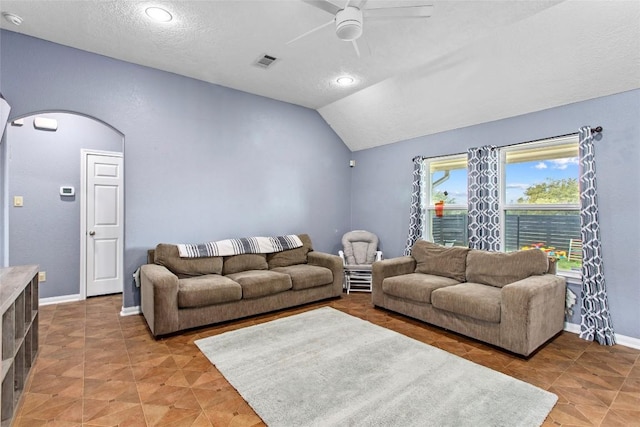 living room with vaulted ceiling, a textured ceiling, and ceiling fan