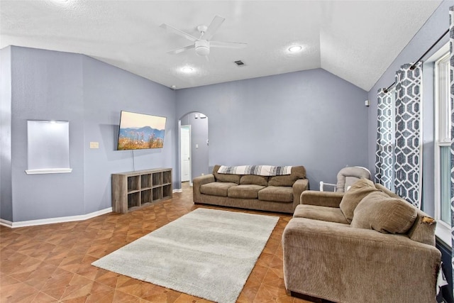 living room featuring ceiling fan, lofted ceiling, and a textured ceiling