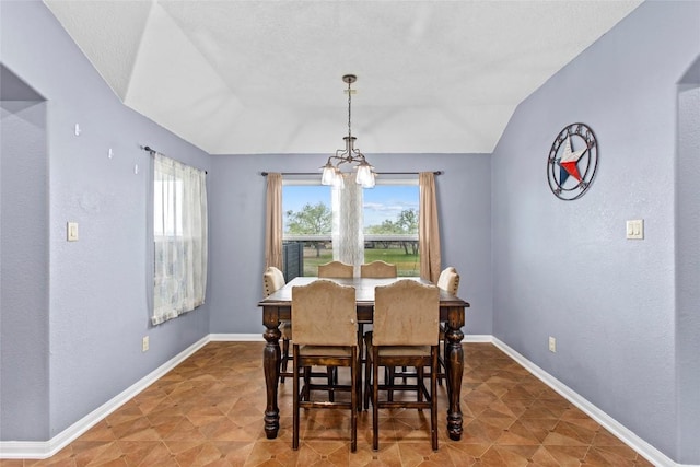 dining space with vaulted ceiling and a notable chandelier