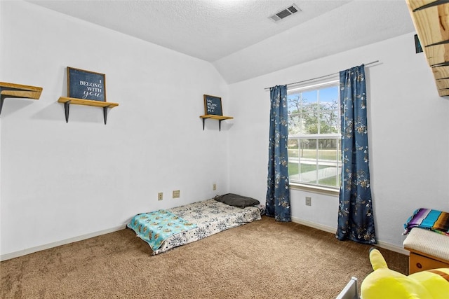 carpeted bedroom with lofted ceiling and a textured ceiling