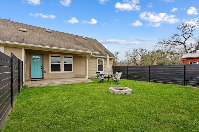 rear view of house featuring a yard and an outdoor fire pit